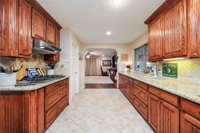 11330 Hillcrest Rd, Dallas, TX 75230 - kitchen featuring arched walkways, decorative backsplash, light tile patterned floors, and under cabinet range hood