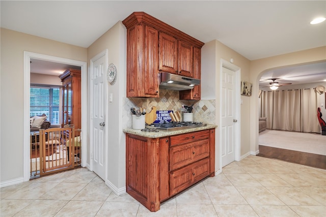 11330 Hillcrest Rd, Dallas, TX 75230 - kitchen with under cabinet range hood, light tile patterned floors, ceiling fan, and backsplash