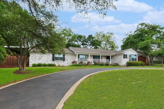 entrance to property featuring brick siding, roof with shingles, and a porch