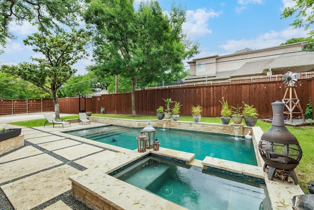 view of swimming pool with a patio, a pool with connected hot tub, and a fenced backyard