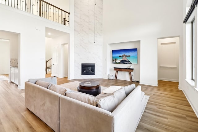 311 Misty Ln, Argyle, TX 76226 - living room featuring baseboards, light wood-style floors, a towering ceiling, and stairs