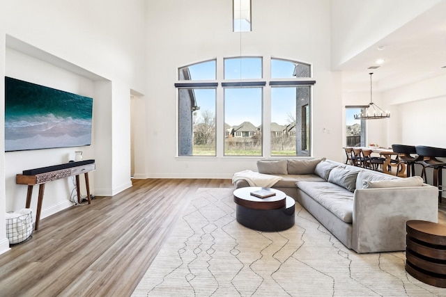 311 Misty Ln, Argyle, TX 76226 - living area with a towering ceiling, baseboards, a chandelier, and light wood-type flooring