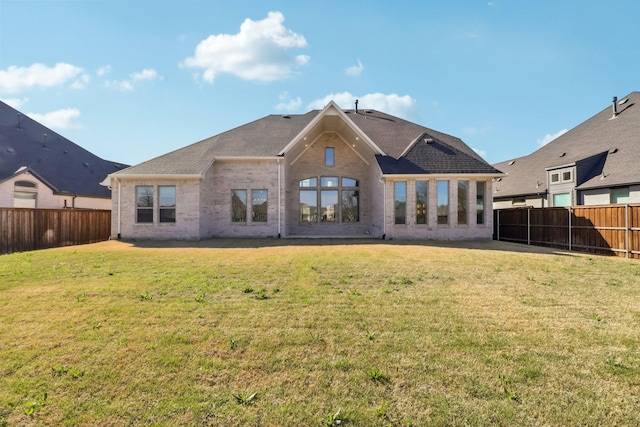 311 Misty Ln, Argyle, TX 76226 - back of house with a fenced backyard, a shingled roof, a lawn, and brick siding