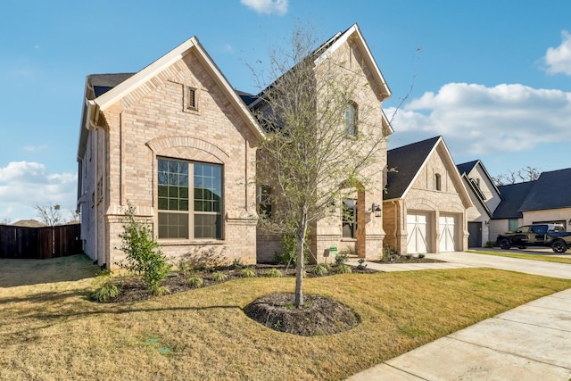 311 Misty Ln, Argyle, TX 76226 - french country style house featuring fence, concrete driveway, a front lawn, and stone siding