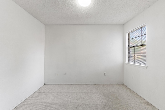 carpeted empty room featuring a textured ceiling