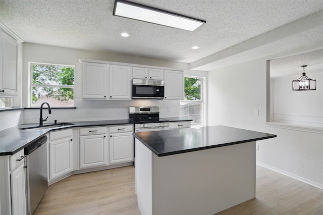 kitchen featuring backsplash, a textured ceiling, appliances with stainless steel finishes, and a sink