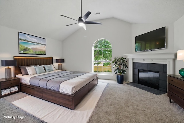 carpeted bedroom featuring visible vents, a ceiling fan, vaulted ceiling, and a tile fireplace