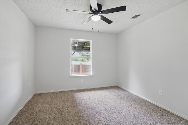 unfurnished room featuring visible vents, carpet, a textured ceiling, and ceiling fan
