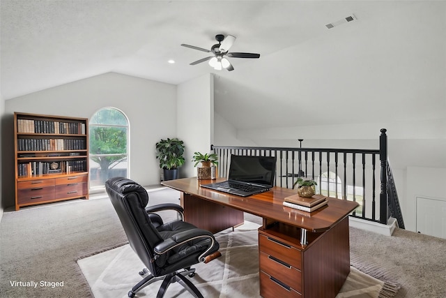 carpeted home office featuring a ceiling fan, visible vents, and lofted ceiling
