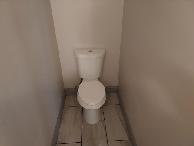 bathroom featuring toilet and baseboards