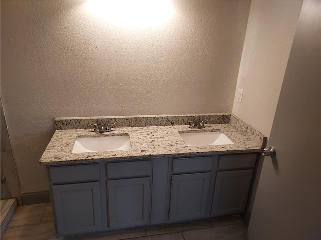 full bathroom featuring a sink, tile patterned floors, and double vanity