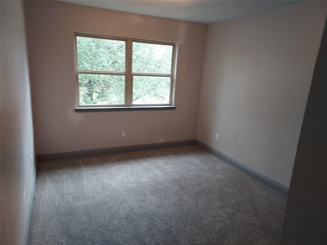 carpeted spare room with baseboards