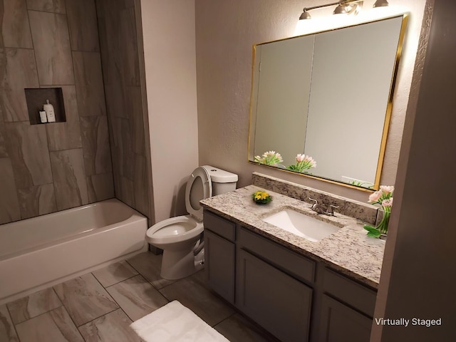 bathroom with vanity, a textured wall, marble finish floor, toilet, and  shower combination
