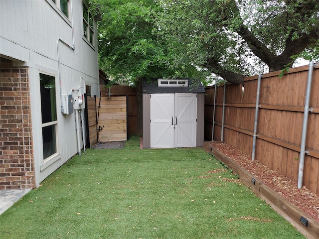 view of yard featuring a storage shed, an outdoor structure, and a fenced backyard