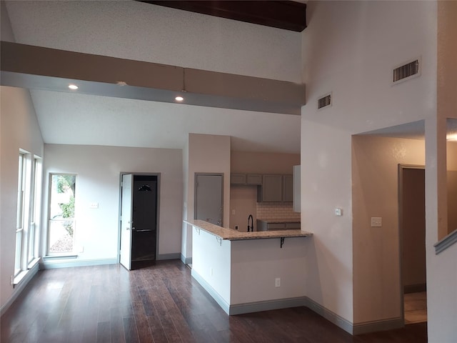 kitchen featuring visible vents, baseboards, a peninsula, and dark wood finished floors