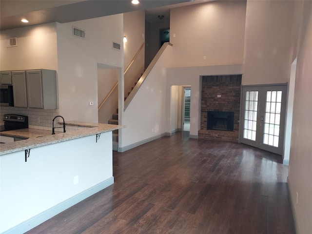kitchen featuring visible vents, electric range, a high ceiling, gray cabinets, and stainless steel microwave