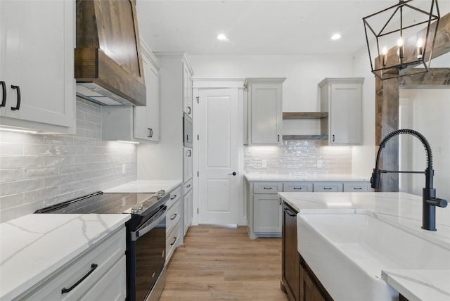 kitchen with tasteful backsplash, open shelves, a sink, custom exhaust hood, and electric stove