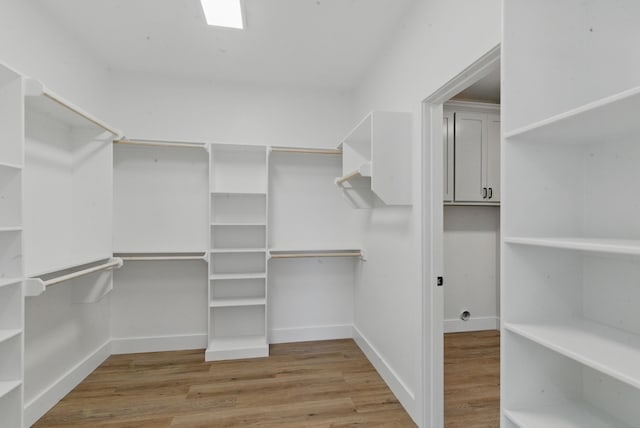 walk in closet with wood finished floors