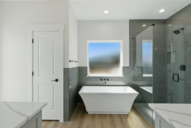 bathroom featuring plenty of natural light, a freestanding bath, and a shower stall