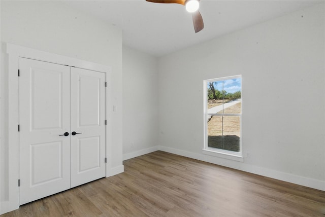 unfurnished bedroom with baseboards, a closet, and wood finished floors