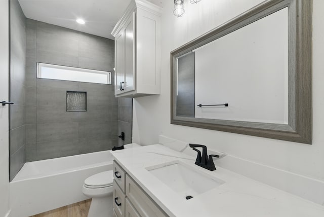 bathroom with toilet, bathtub / shower combination, wood finished floors, and vanity