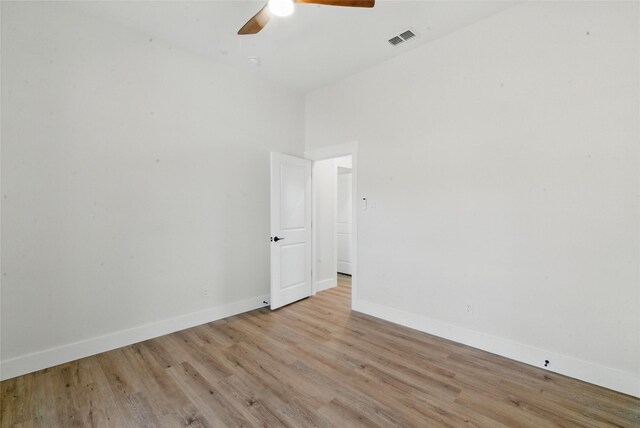 spare room featuring visible vents, a ceiling fan, baseboards, and wood finished floors