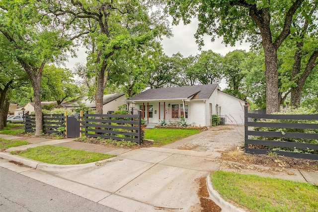 view of front of home with a gate, a fenced front yard, and concrete driveway