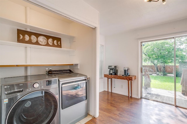 laundry room with laundry area, light wood-type flooring, and washing machine and clothes dryer