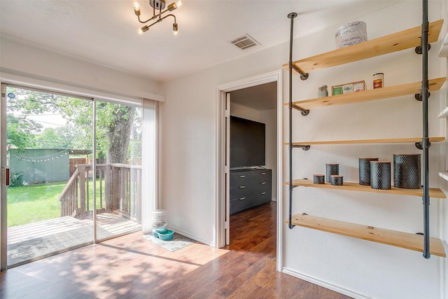 interior space with baseboards, visible vents, and wood finished floors