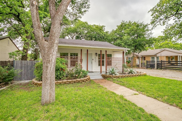 view of front of home with a porch, a front lawn, and fence
