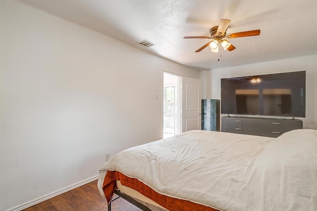 bedroom featuring a ceiling fan, baseboards, visible vents, and wood finished floors