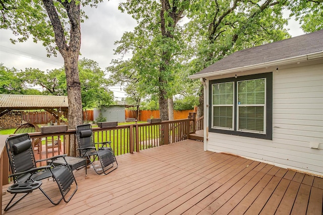 deck featuring a storage shed, a yard, an outdoor structure, and a fenced backyard