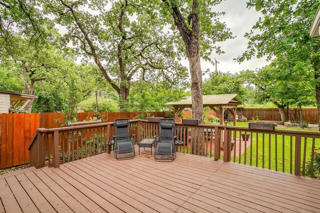 wooden terrace with a gazebo, a fenced backyard, and a lawn