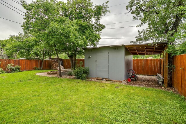 view of yard with a fenced backyard, a shed, and an outbuilding