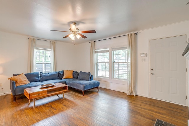 living area featuring baseboards, a ceiling fan, wood finished floors, and visible vents