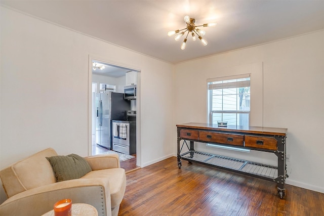 sitting room with baseboards, a chandelier, and wood finished floors