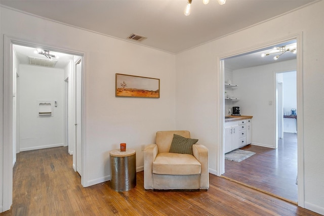 living area with baseboards, visible vents, and dark wood finished floors