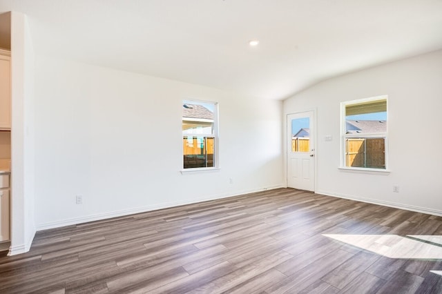 unfurnished living room featuring baseboards, recessed lighting, wood finished floors, and lofted ceiling