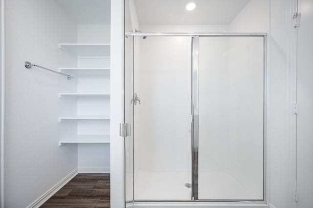 full bath with baseboards, a stall shower, recessed lighting, and wood finished floors