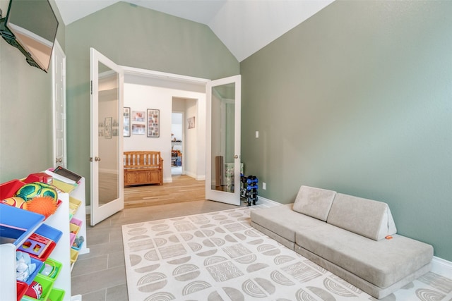 living room with baseboards, french doors, and lofted ceiling