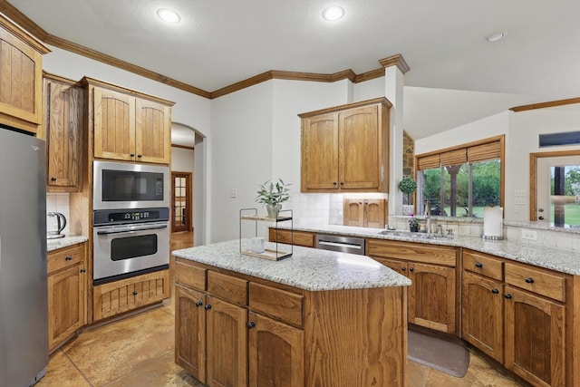 kitchen with backsplash, crown molding, arched walkways, a sink, and stainless steel appliances