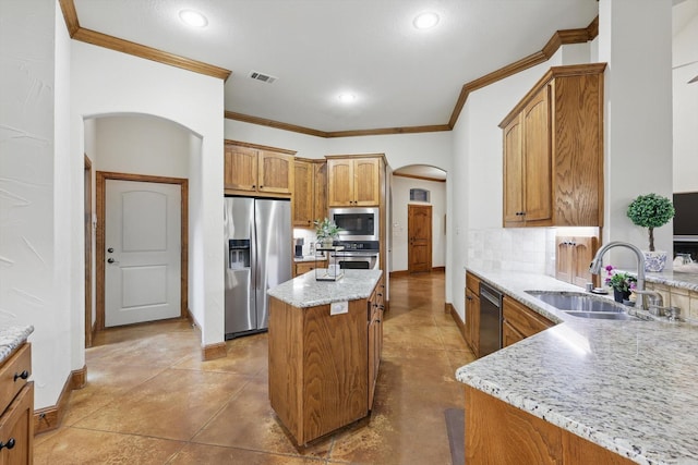 kitchen with crown molding, appliances with stainless steel finishes, a sink, arched walkways, and visible vents