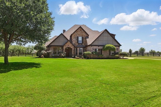 view of front of house with a front lawn, fence, stone siding, and a chimney
