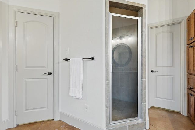 bathroom featuring tile patterned flooring, baseboards, and a stall shower