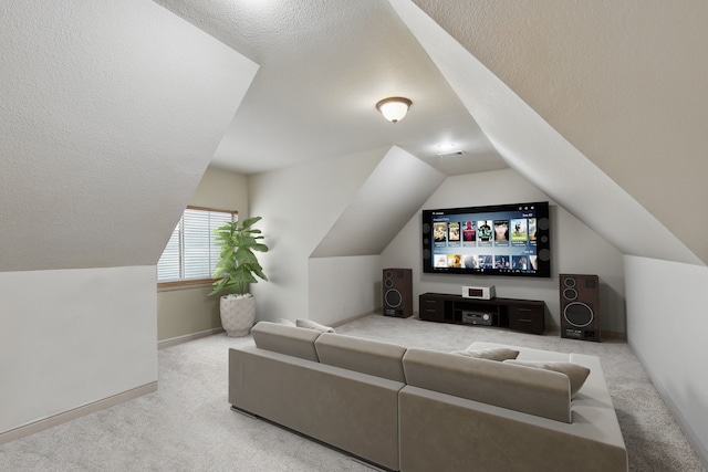 carpeted home theater featuring a textured ceiling, baseboards, vaulted ceiling, and visible vents