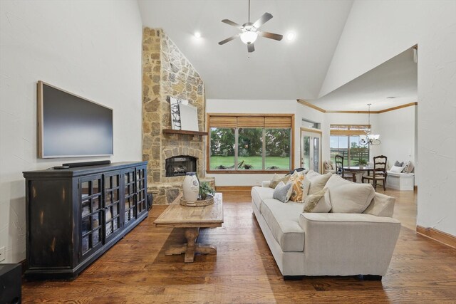 living area featuring a fireplace, wood finished floors, high vaulted ceiling, baseboards, and ceiling fan with notable chandelier
