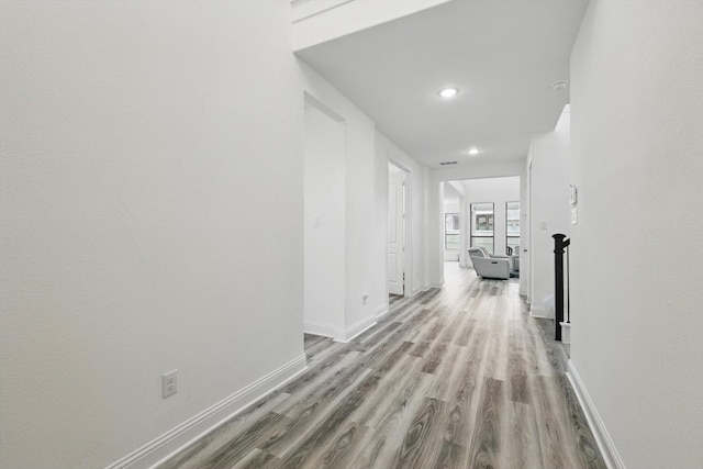 hall featuring baseboards, recessed lighting, wood finished floors, and visible vents