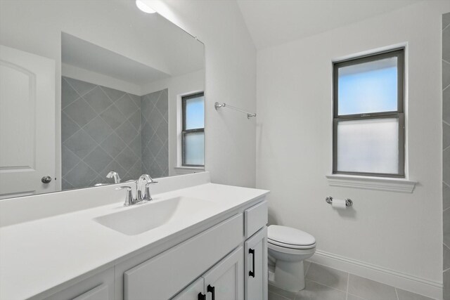 full bath featuring vanity, baseboards, tile patterned floors, and toilet
