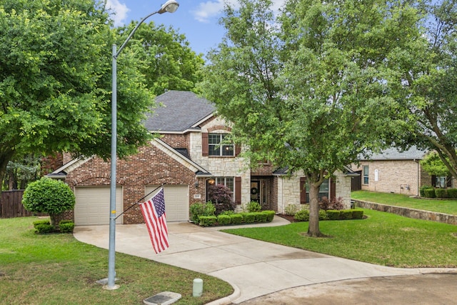 traditional-style home with fence, stone siding, a front yard, an attached garage, and driveway