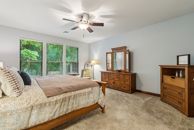carpeted bedroom with baseboards, ceiling fan, and visible vents